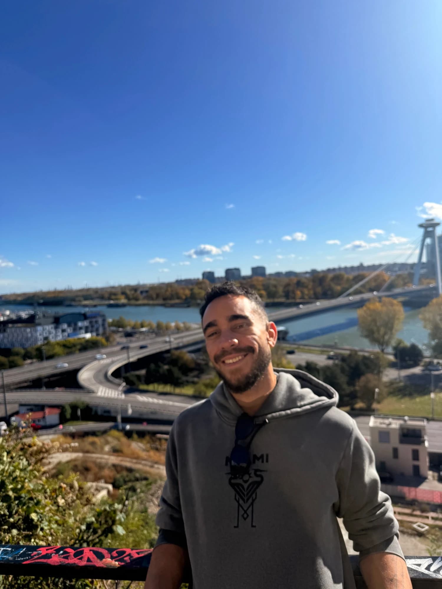 Douglas Pessoa smiling at a riverside viewpoint